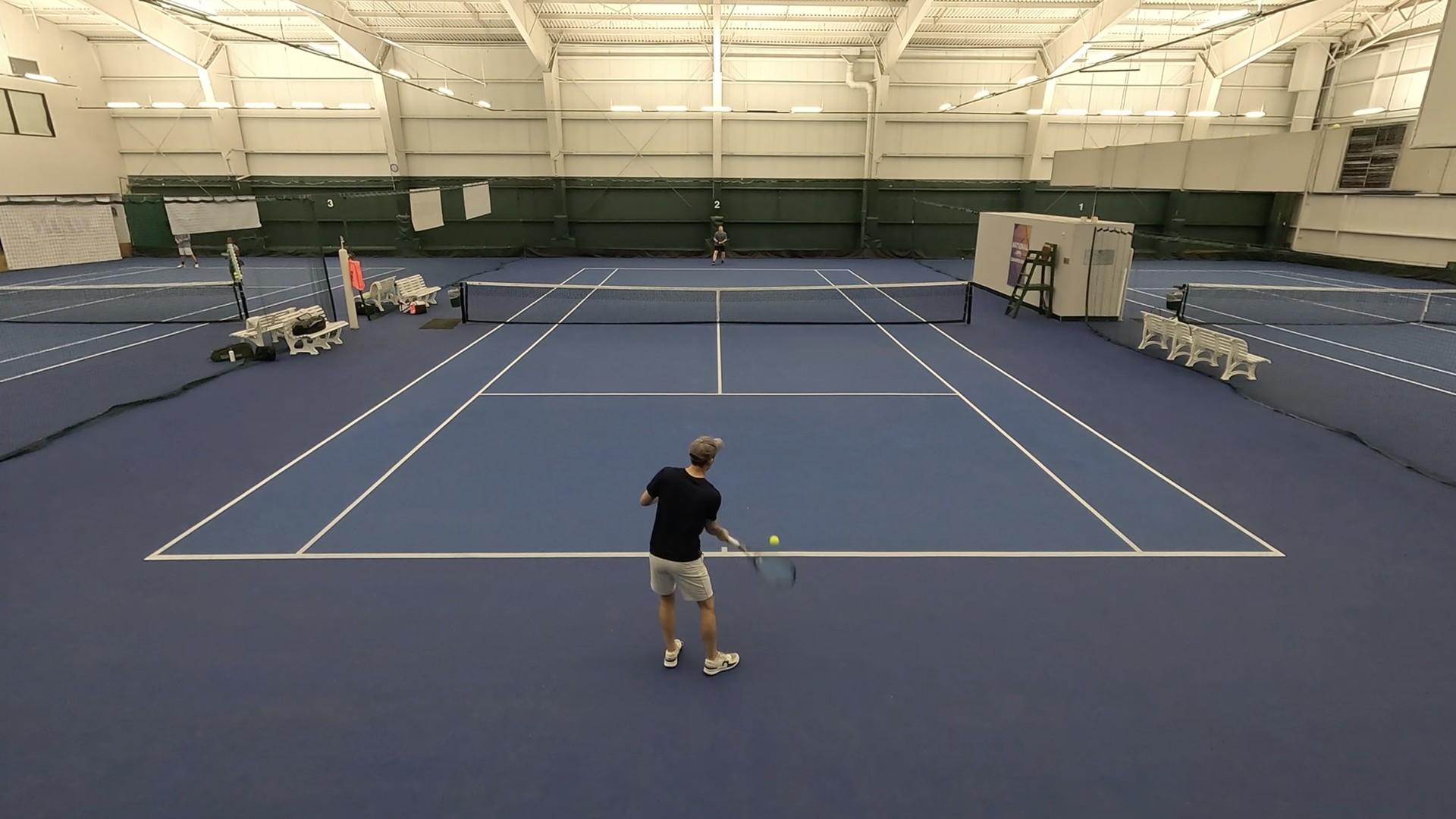 Tennis rally on an indoor court